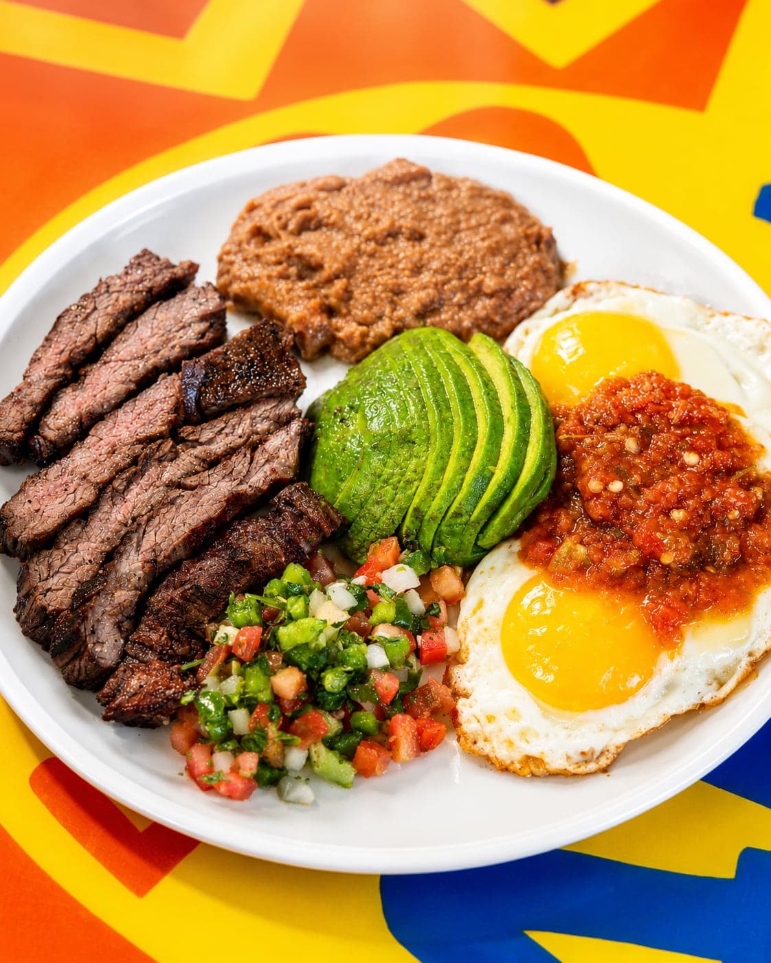 Tejano Plate: carne asada, huevos estrellados con salsa, frijoles, aguacate y pico de gallo — El Taco Mañanero